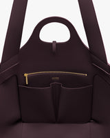 Open handbag with front zipper pocket and handle at the top.