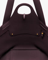 Close-up of an open handbag with visible stitching and metal studs.