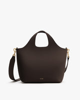 Tote bag with a curved handle and detachable strap, featuring gold clasps.