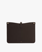 Leather laptop sleeve with a tab closure and two rivets at the top corners.