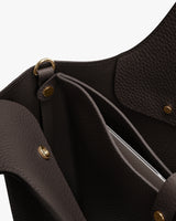 Open leather handbag with laptop sleeve attached via gold snap buttons