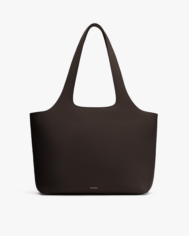 Tote bag with textured surface and long handles.