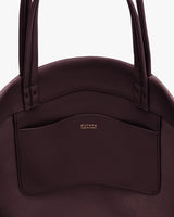 Close-up of a handbag with handles and a front pocket.