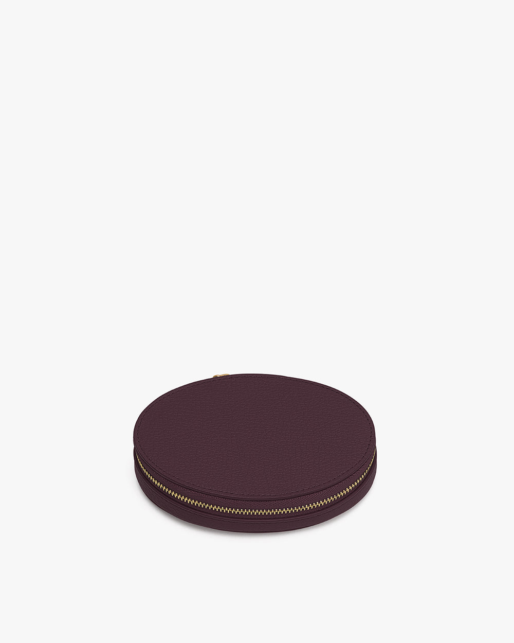 Round case with zipper closure lying flat on surface