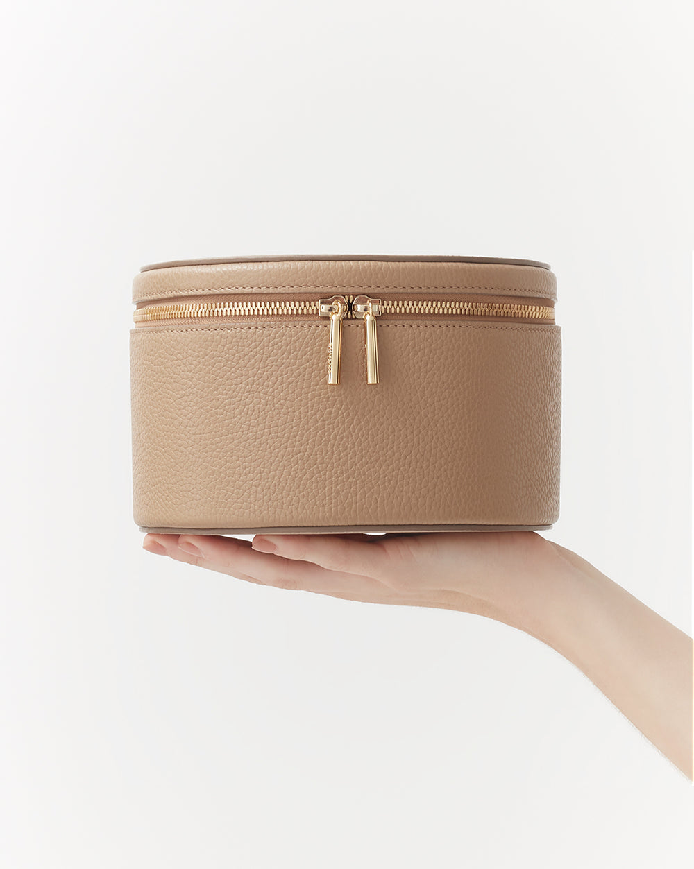 Hand holding a small round zippered case
