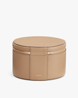 Round jewelry box with a zipper closure.