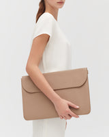 Person holding a large leather laptop sleeve