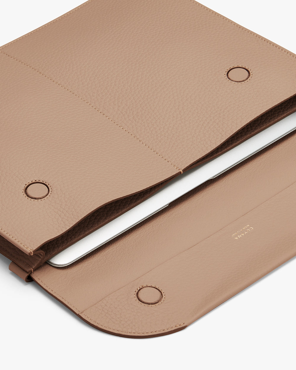 Laptop in an open sleeve with a snap closure.