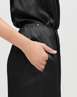 Person with hand in pocket of a high-waisted outfit