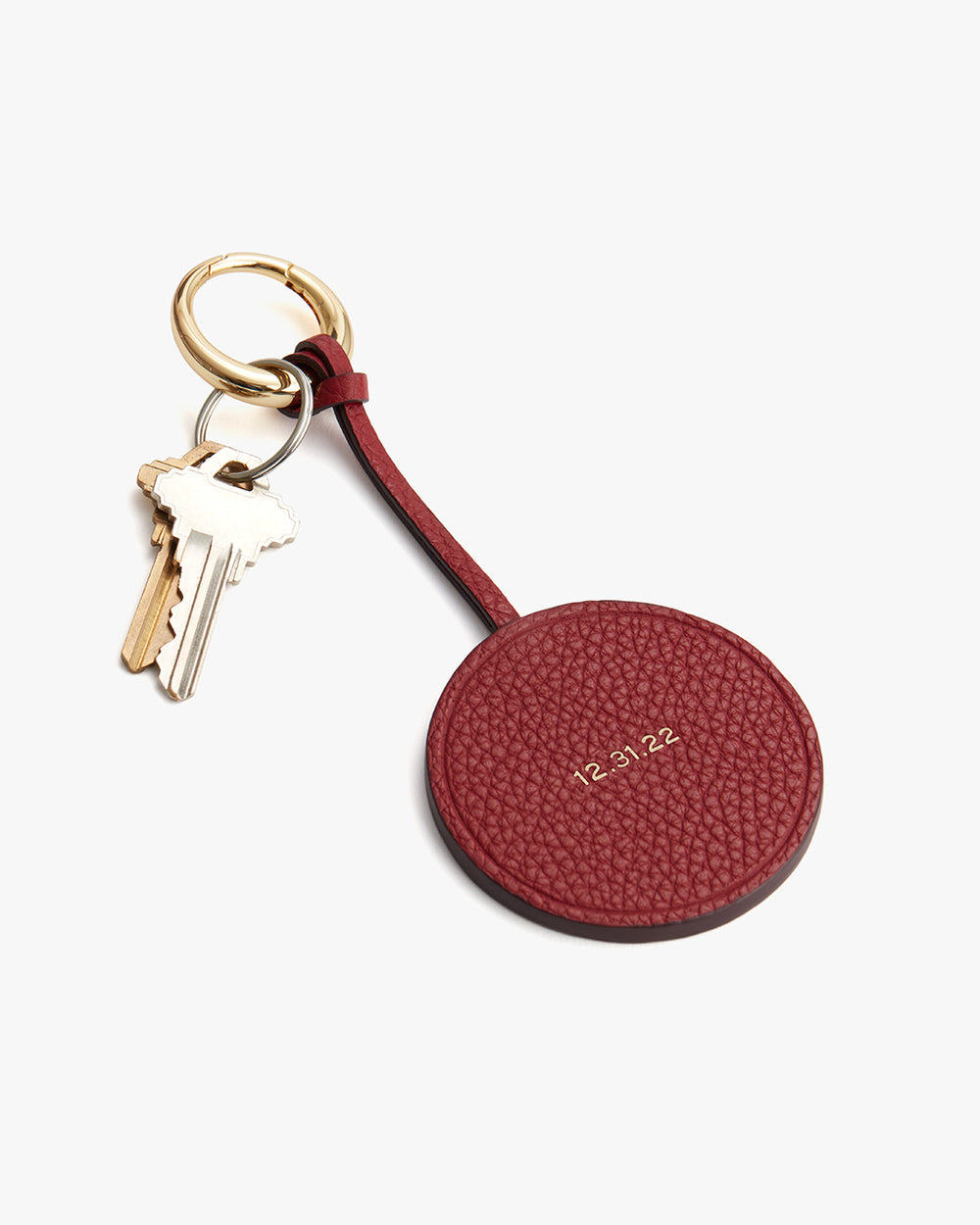 Round keychain attached to keys on a white background