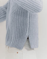 Knitted sweater and scarf over a shirt on a hanger