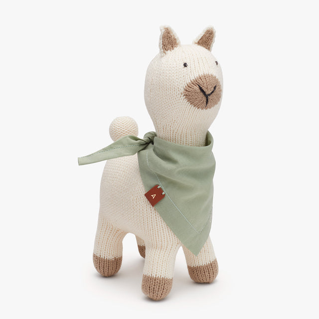 Stuffed alpaca toy in the shape of a standing dog with a scarf.