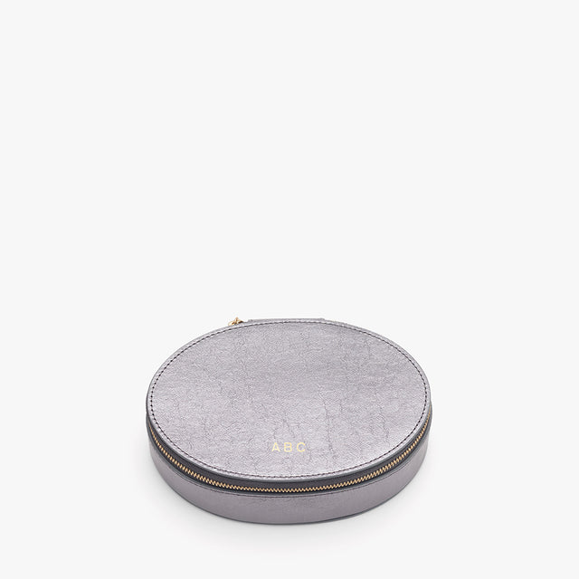 Round case with zipper and monogram initials on top.
