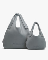 Two handbags of different sizes with the text Fewer, better printed on them.