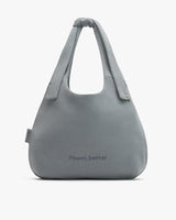 Large shoulder bag with text on the front and a top handle.