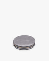 Round metal container with a textured edge on a plain background.