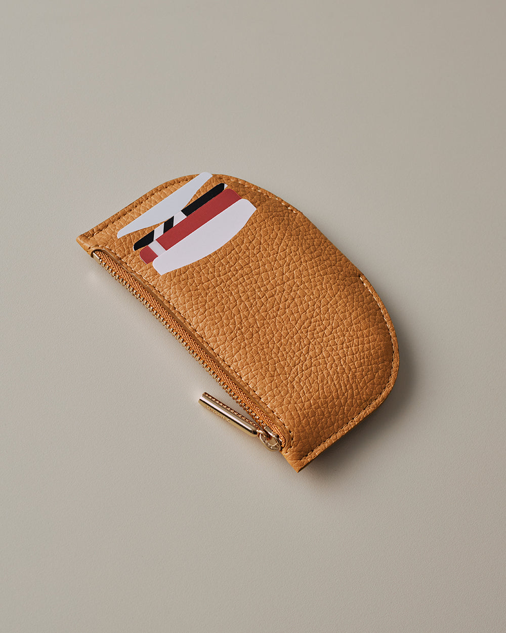 Small semi-circle wallet with cards partially visible.