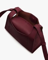 Open handbag with handle and visible interior pouch.