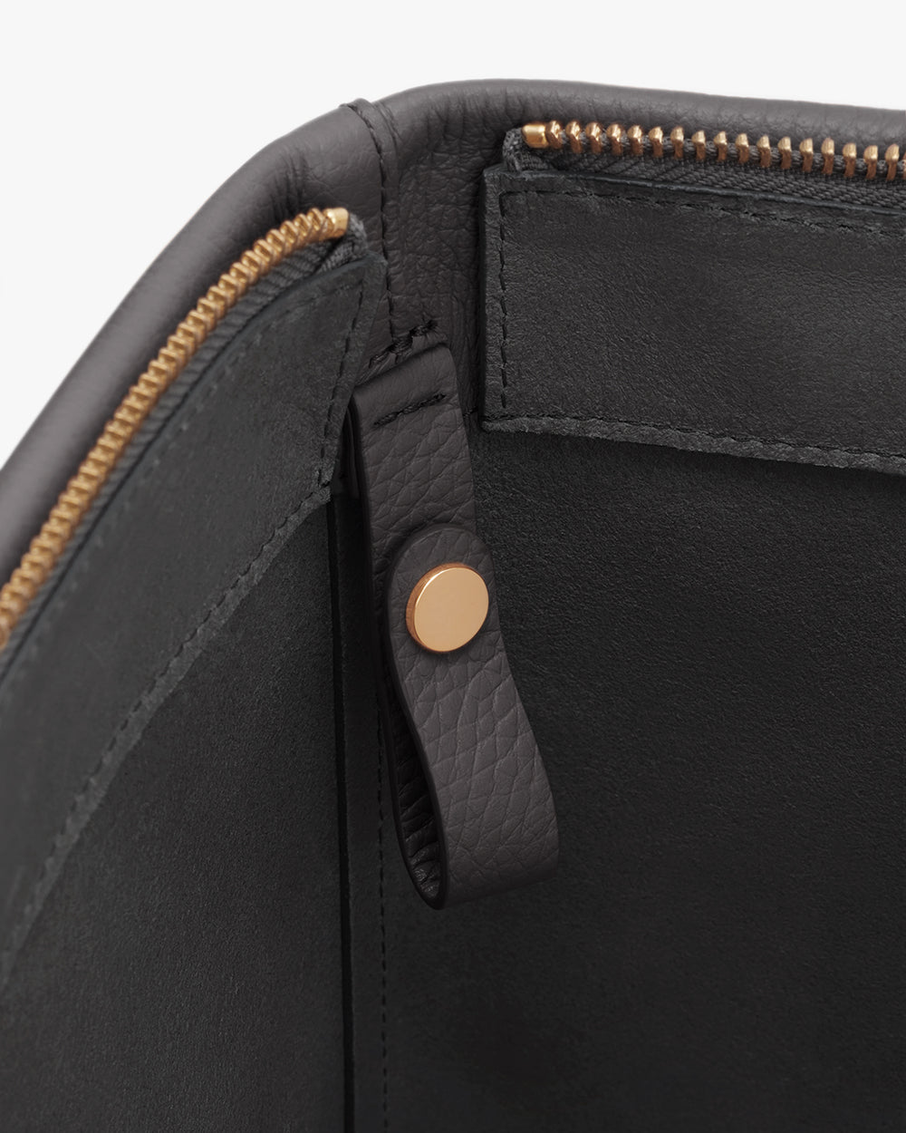 Close-up of a bag interior with a zipper and button detail.