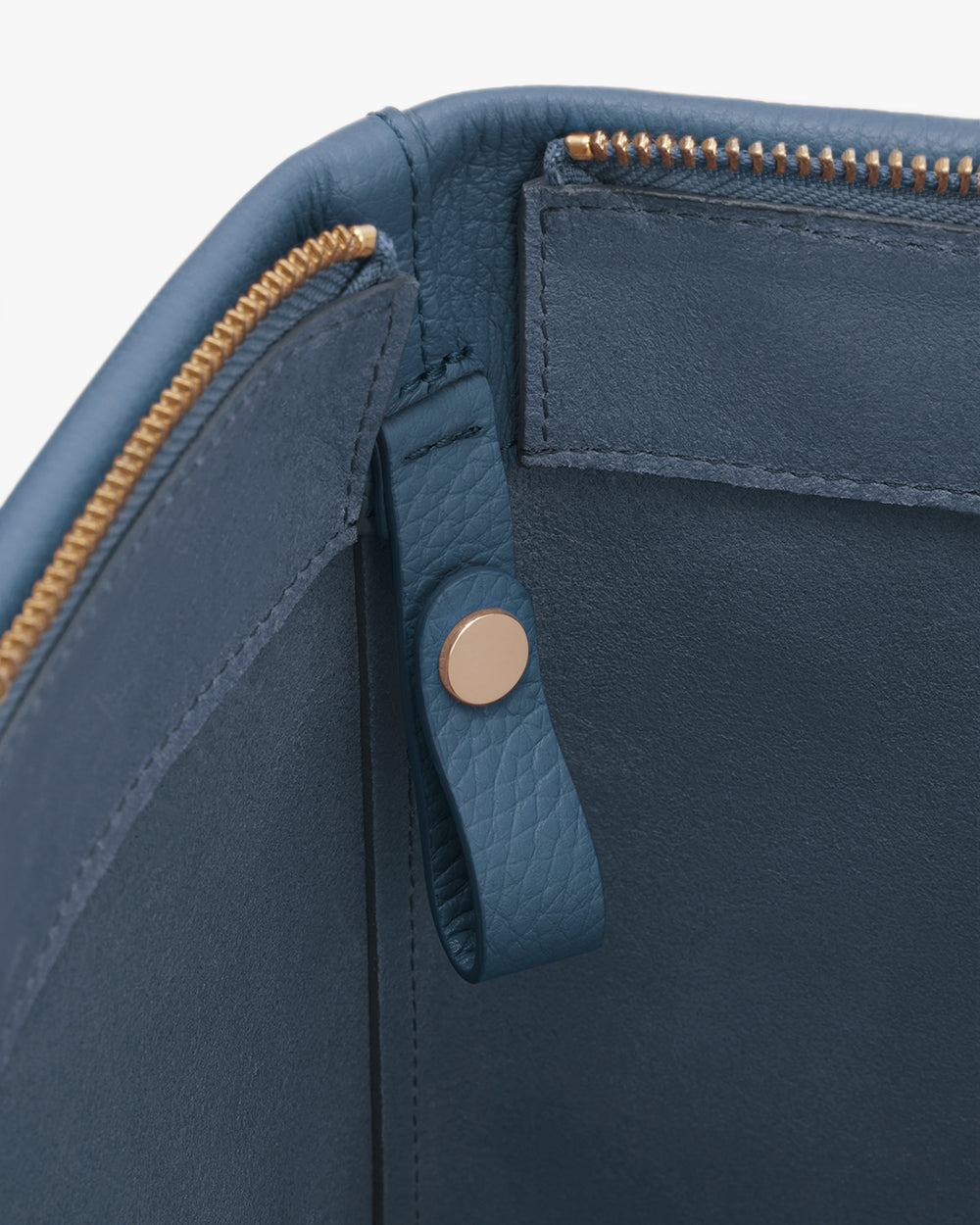 Close-up of a bag interior with a zipper and snap button strap.