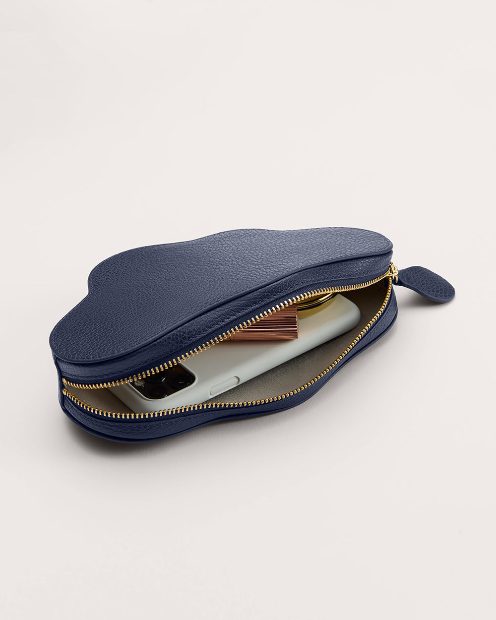 Cloud-shaped pouch with a phone and wallet inside, partially unzipped.