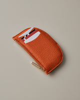Small textured pouch with a zipper and multiple card slots.