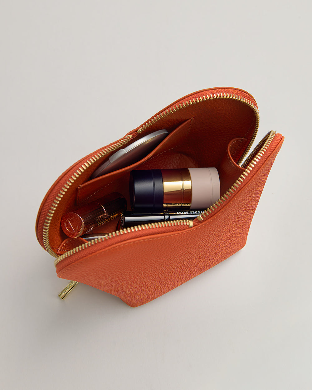 Zippered pouch containing makeup and skincare products.