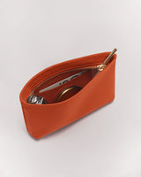 Pouch with zipper, containing compact, phone, and small bottle.