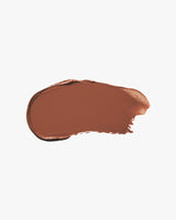 Smudge of brown, cream eyeshadow on plain background.