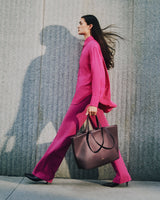 Person walking with large tote bag against textured wall