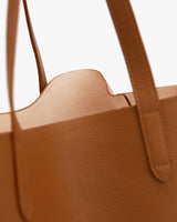 Close-up of a textured handbag with handles.