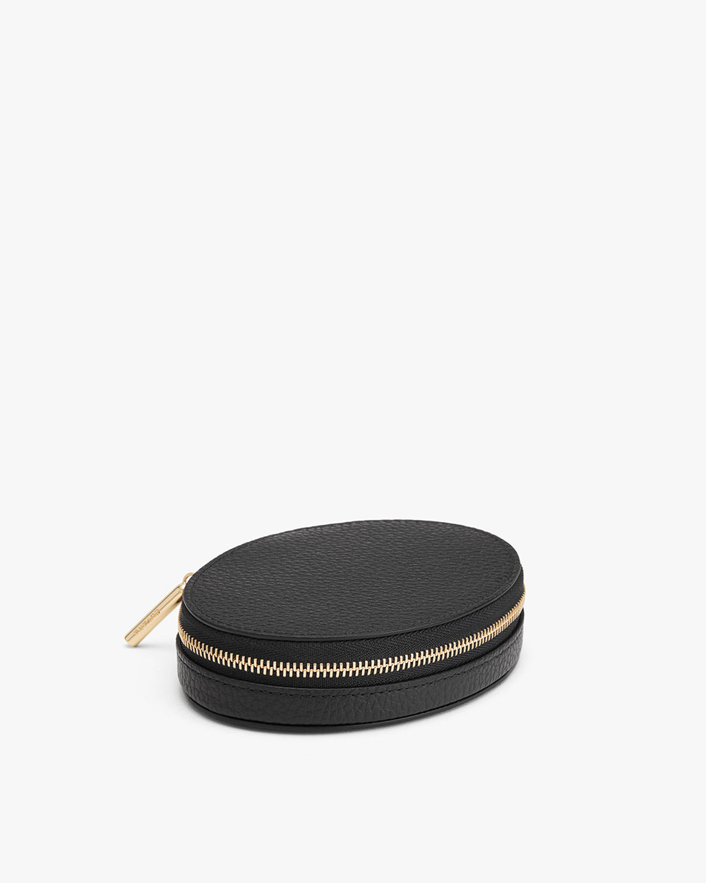 Round zippered case with a textured surface and a metallic zipper pull.