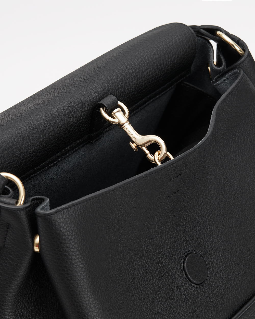 Close-up view of an open handbag showing the clasp and inner lining.