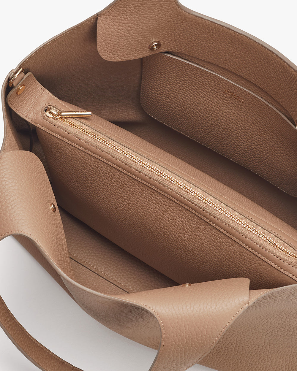 Open handbag showing interior with zippers.