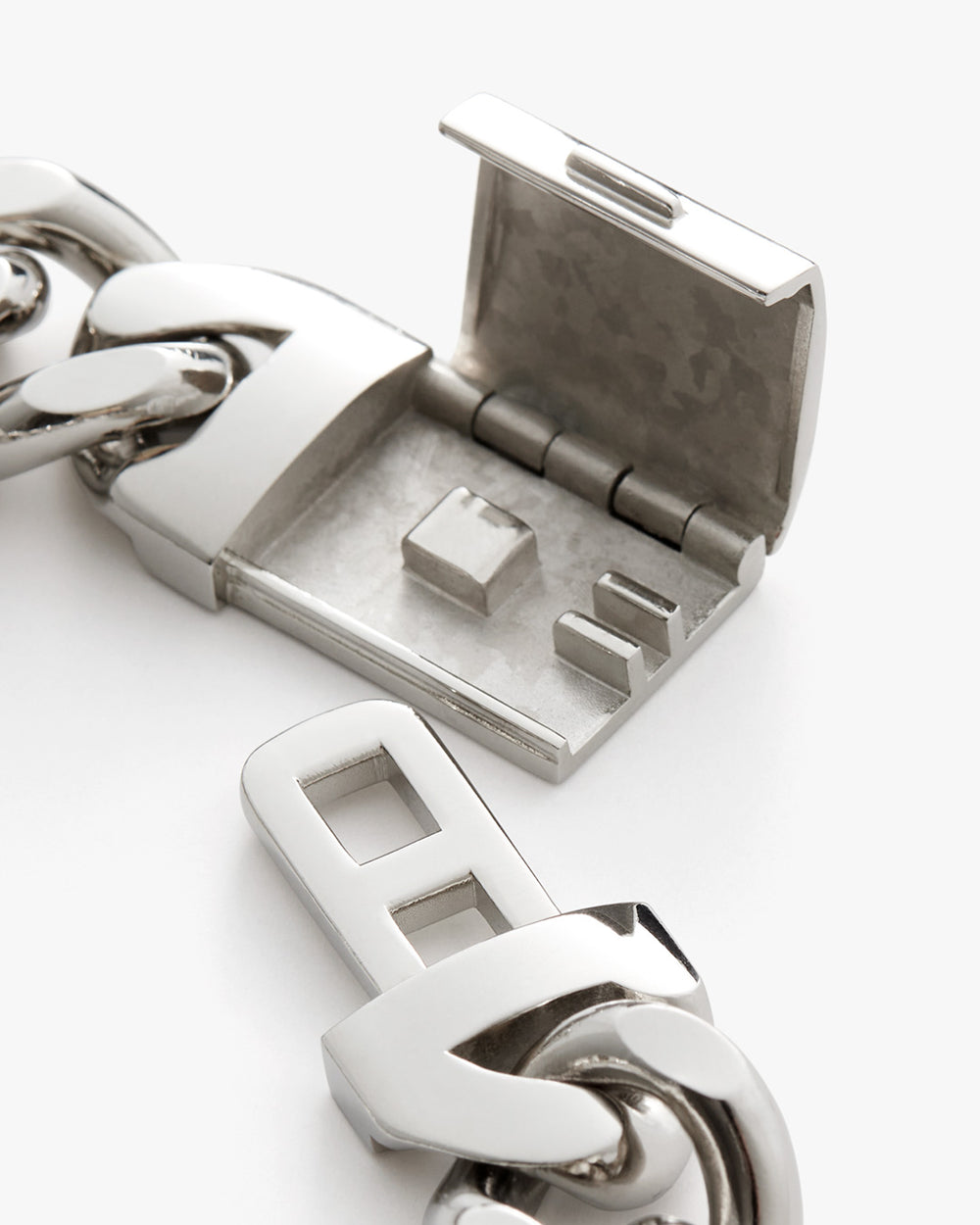 Close-up of an open metal clasp attached to a chain.