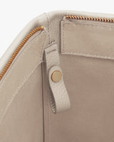 Close-up of a bag with zipper and snap button detail.