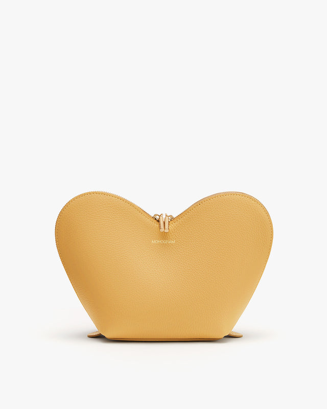 Heart-shaped purse with a zipper on a plain background.