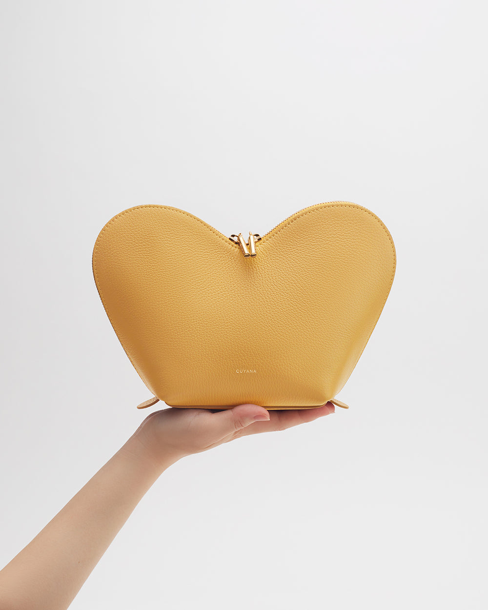 Hand holding a heart-shaped pouch.