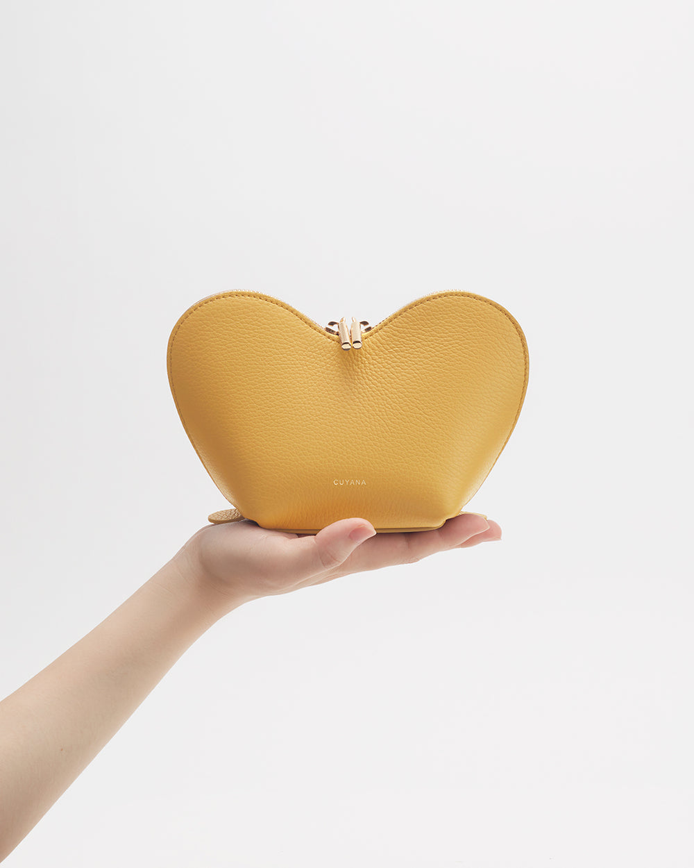 Hand holding a heart-shaped purse