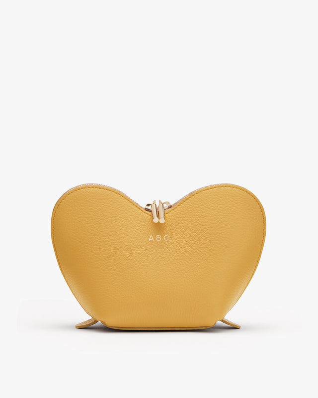 Heart-shaped purse with a zipper and initials A.B.C on front.