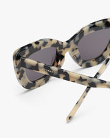 Cat-eye sunglasses with patterned frame and dark lenses.