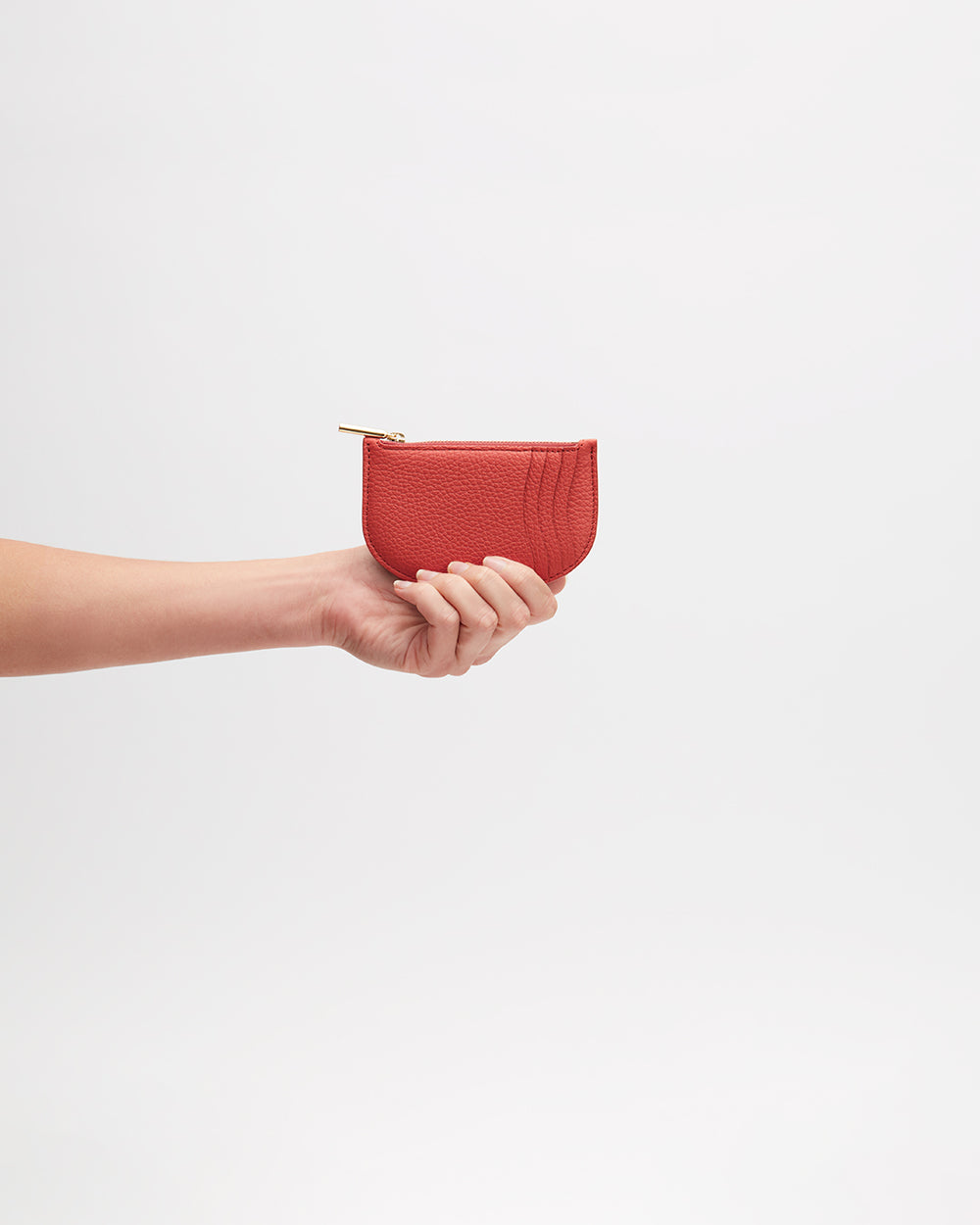 Hand holding a small wallet.