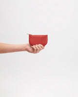 Hand holding a small wallet.