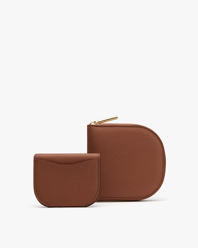 Two simple wallets placed side by side. The larger one with zipper