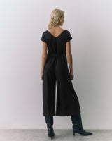 Person wearing a jumpsuit with boots, viewed from the back.