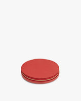 Round leather zippered pouch on a plain background.