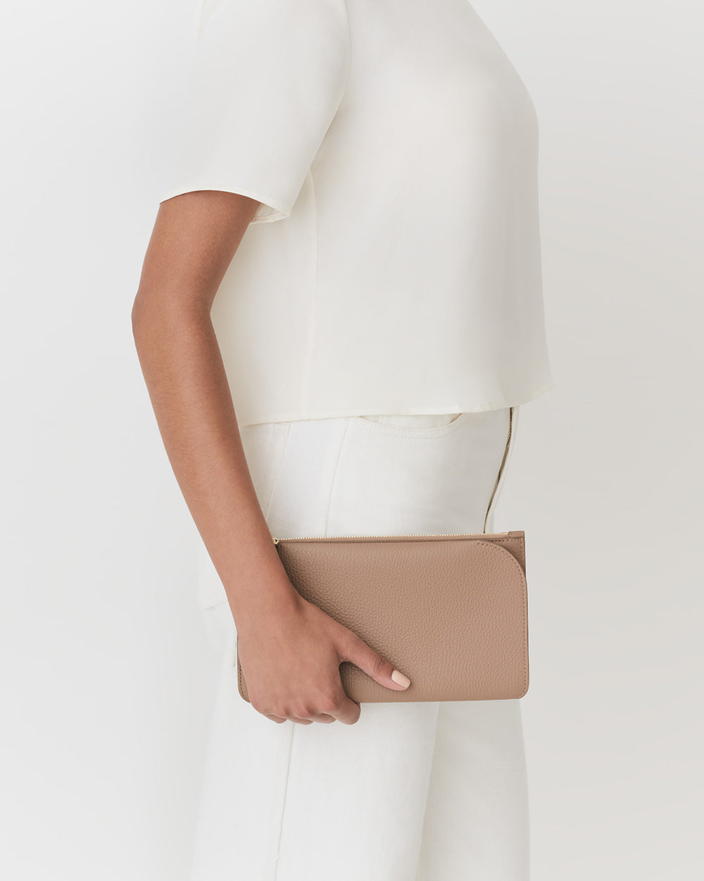 Person holding a clutch bag at their side