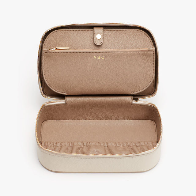 Open jewelry case with compartments and zipper closure.