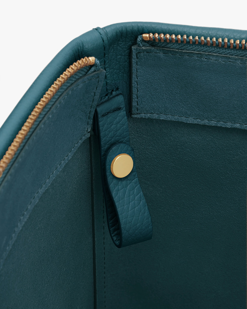 Close-up of a travel bag with a zippered compartment and a snap button on a strap.