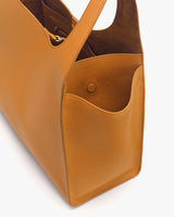 Close-up view of an open handbag with a visible inner compartment and small front pocket.